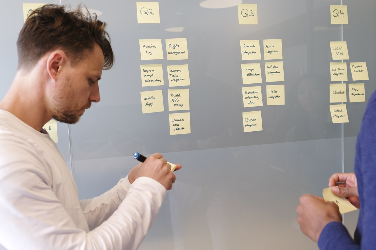 Consultant animant un atelier devant un tableau couvert de notes.